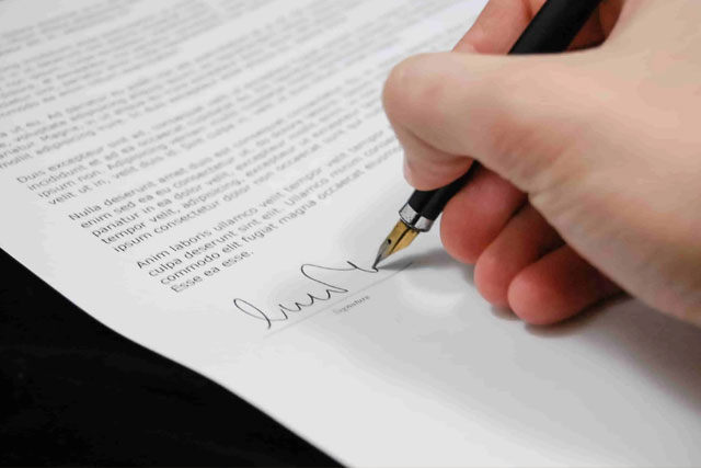 Image of person signing document