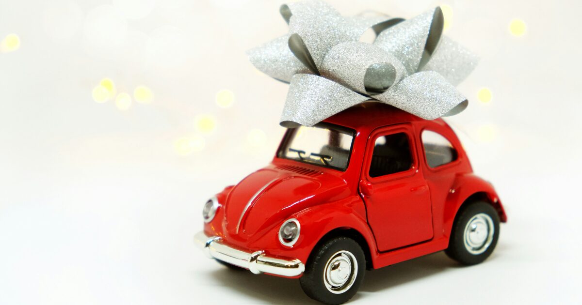 Red car presented as a gift, with a bow on top.