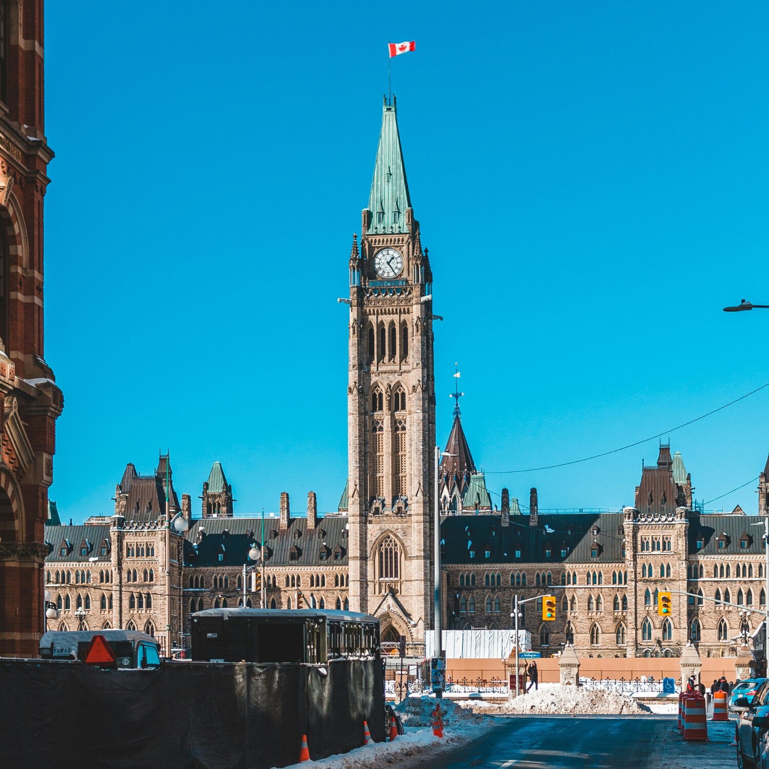 The Peace Tower on Parliament Hill in Ottawa. It is made of brown stone and has a clock on the front of the tower.