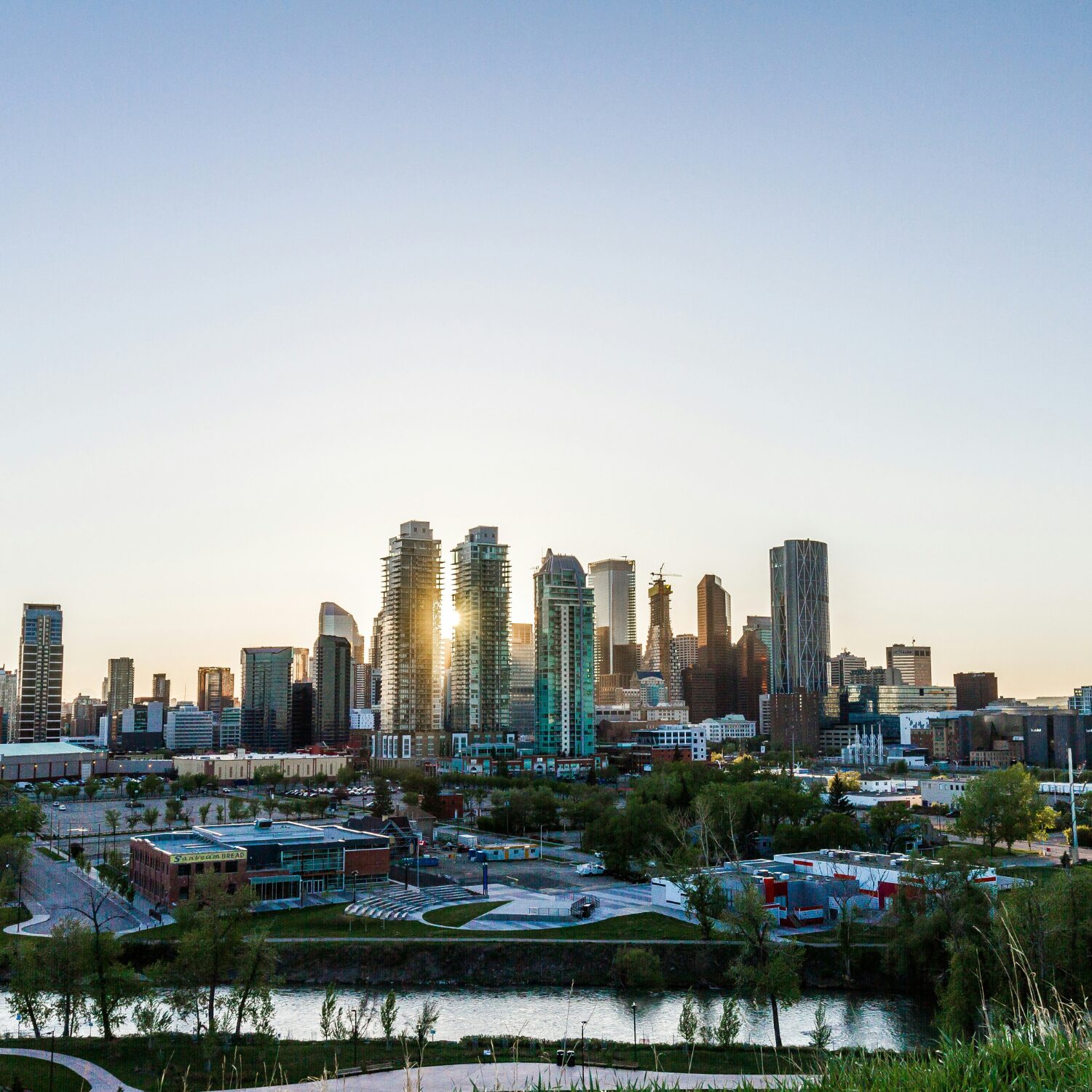 Downtown Calgary's skyline with the sunrise behind it.