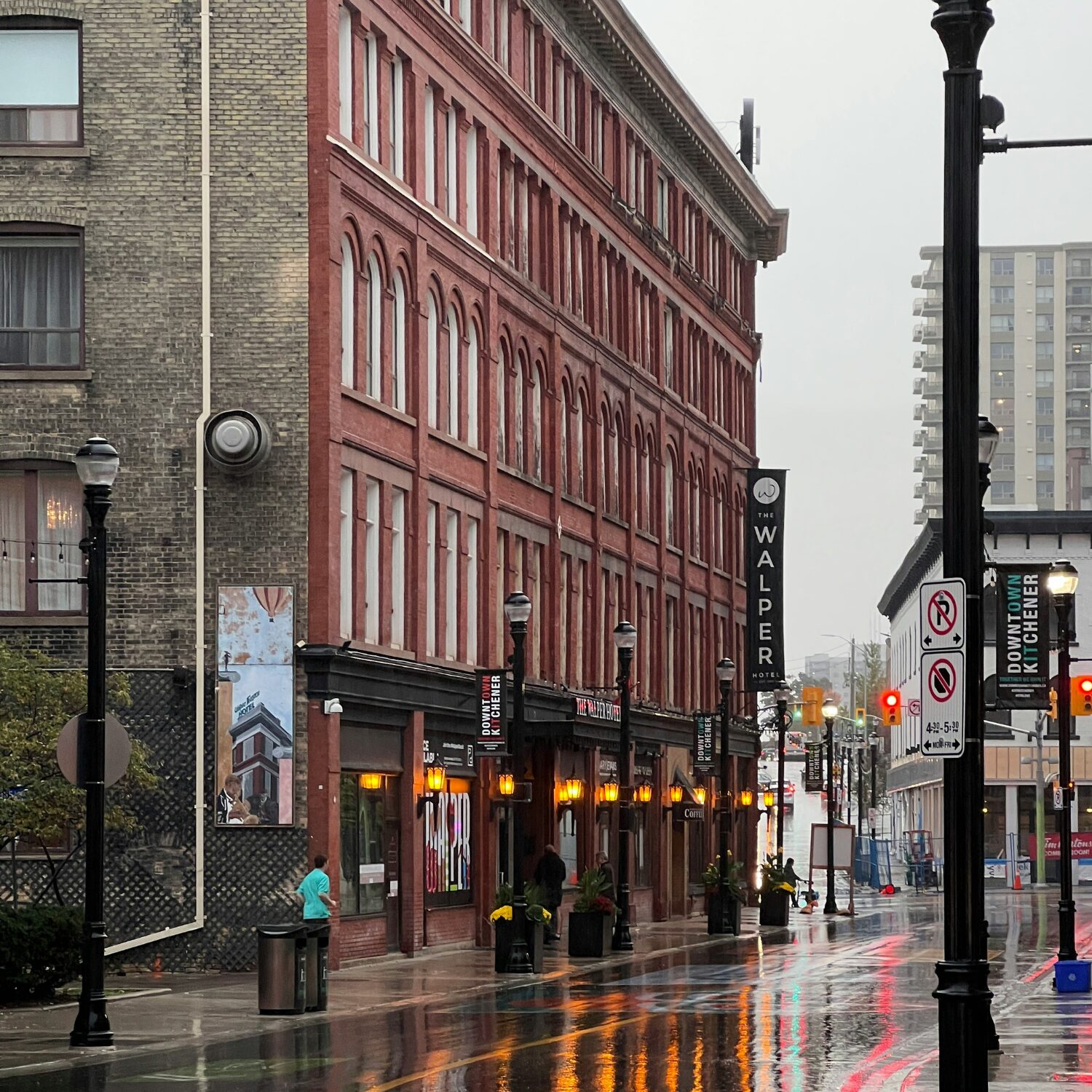 A rainy street in Kitchener, Ontario with stores on the left.