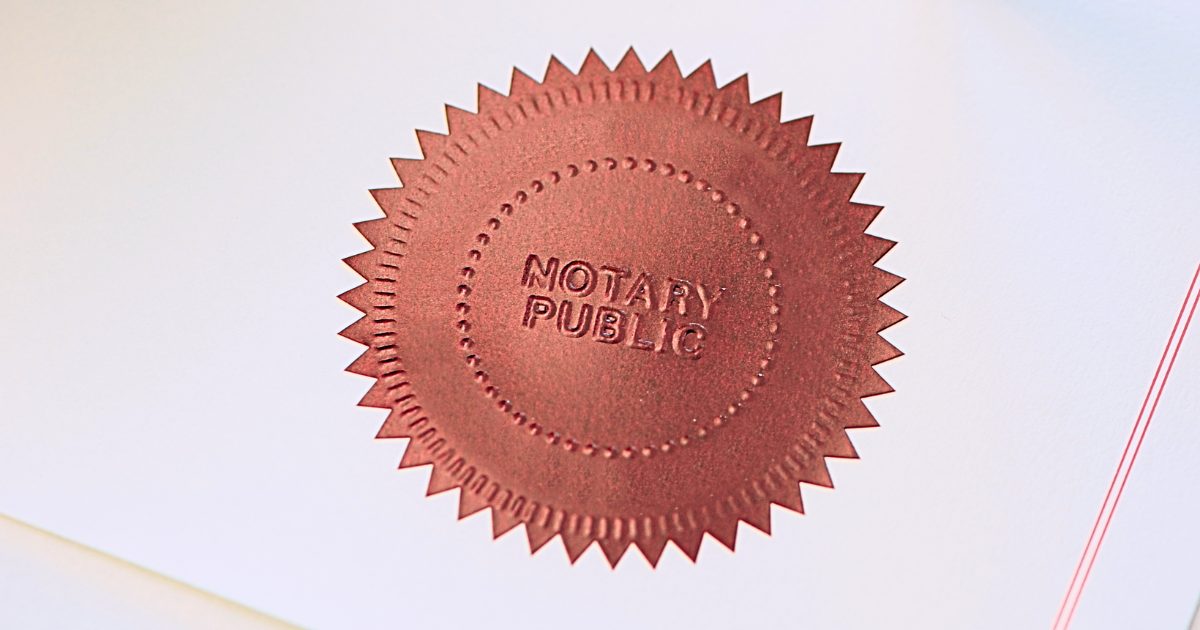 Red foil seal embossed with the word "notary" on a piece of paper