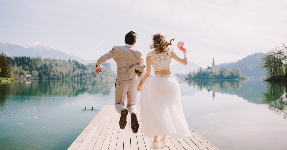 Bride and Groom jumping on dock