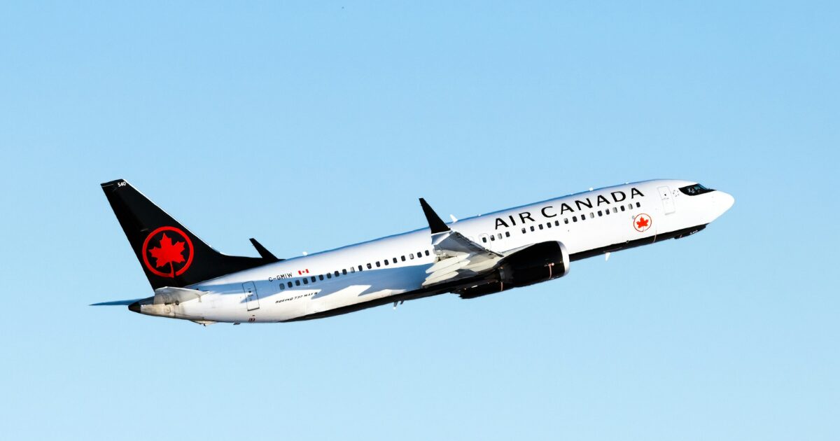 Air Canada plane flying up in the air in a blue sky