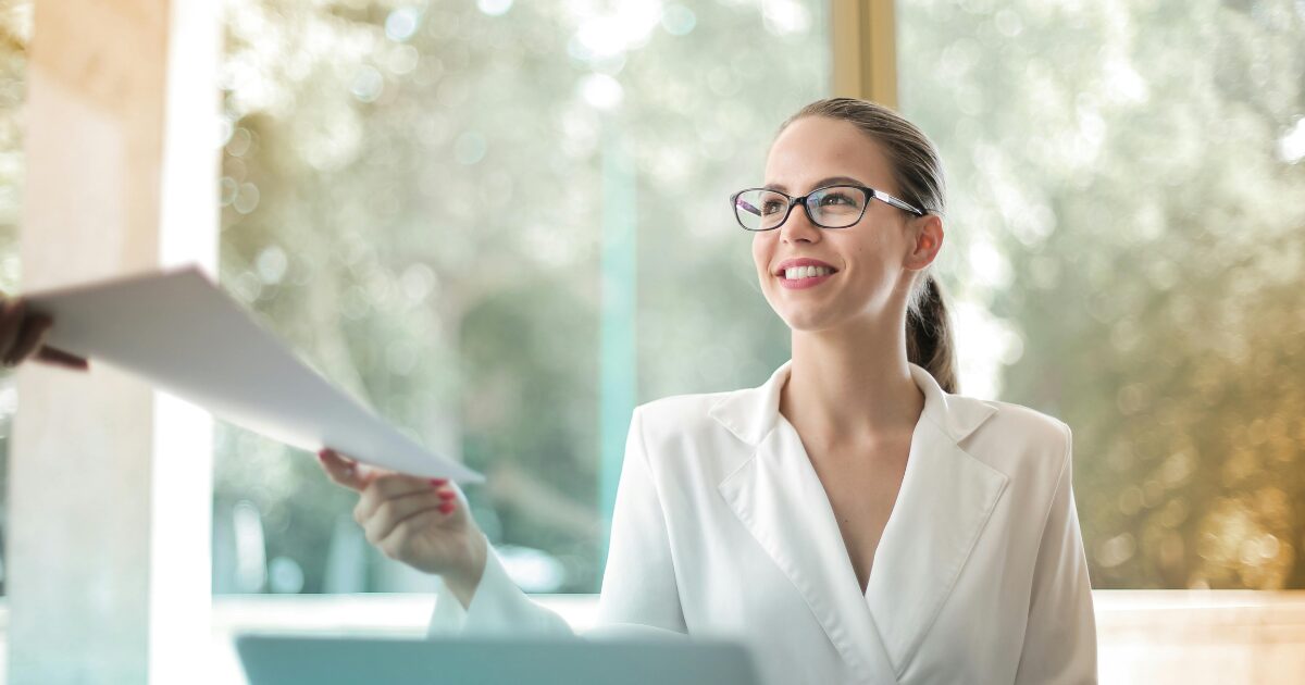 A young woman accepting vehicle registration documents at a ServiceOntario office.