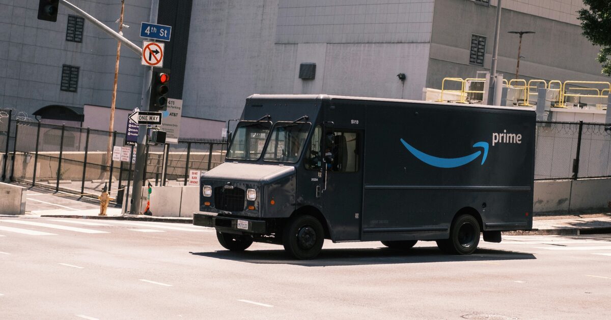 Dark grey Amazon company vehicle on driving on the road.