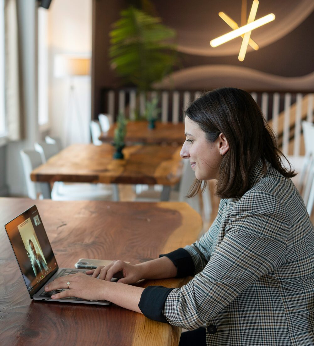 young woman in a blazer on a video call getting a document drafted by an expert.