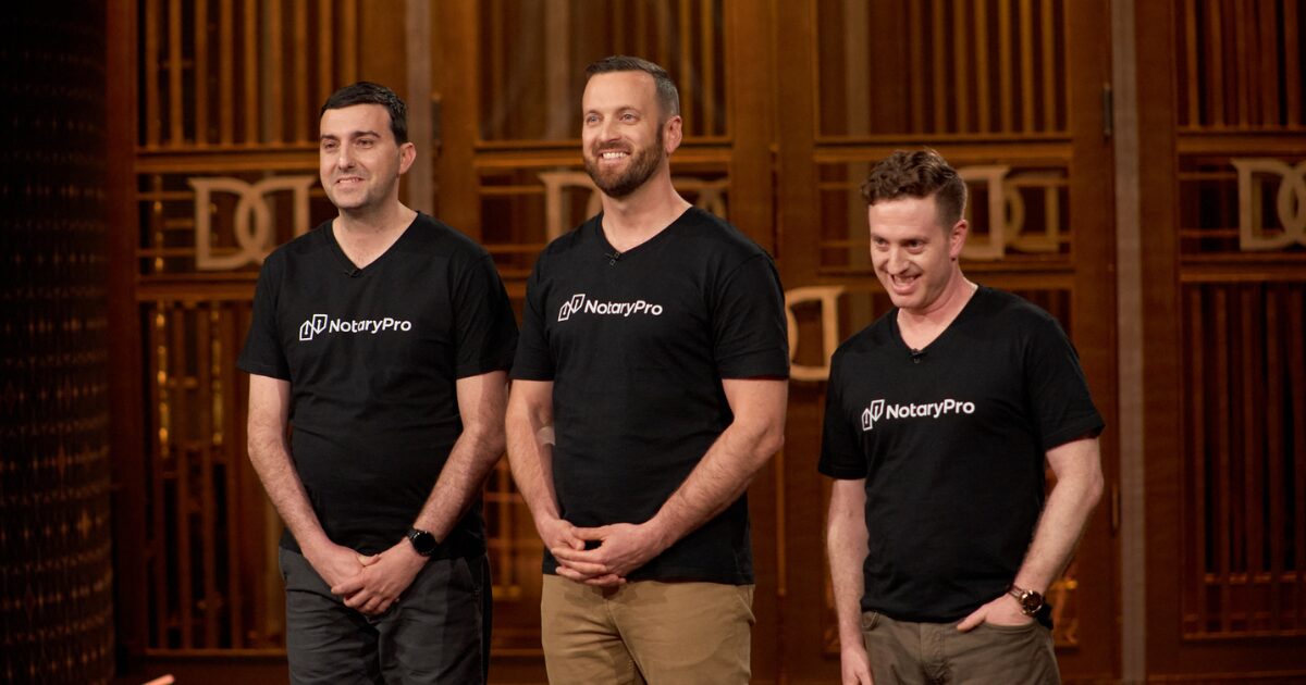 3 young male Caucasian NotaryPro executives standing side by side in the Dragons' Den.