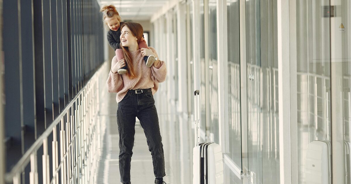 266 A Caucasian woman is smiling while a young Caucasian girl sits on top of her shoulders. The girl is smiling and they are looking at each other.