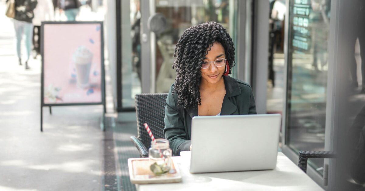 282 A Black woman wearing a black blazer smiling while in front of her laptop