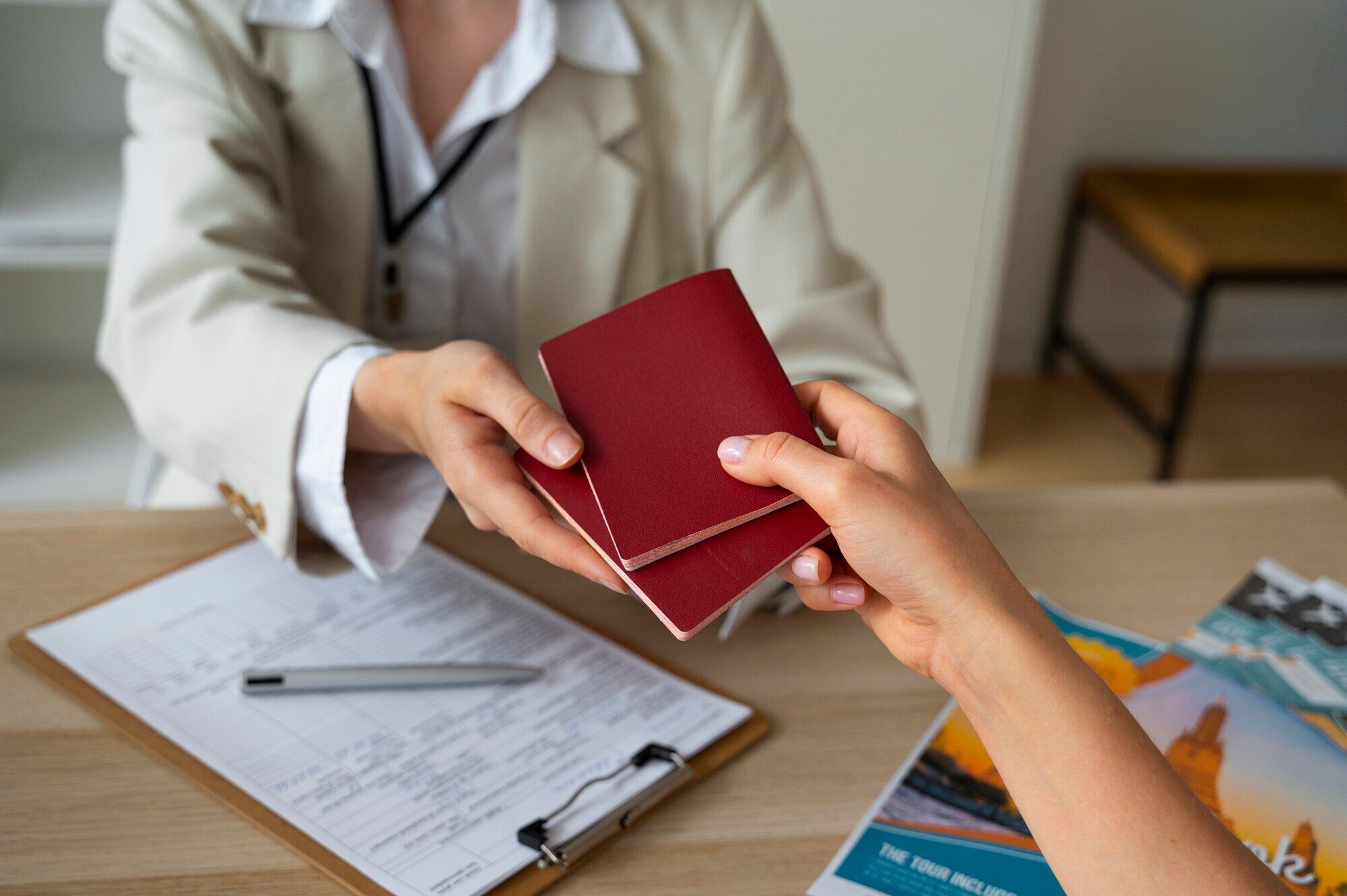 a woman handing over her passports to a visa officer