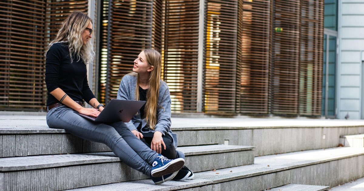 In-Blog-Thumbnails-46 Individuals setting on steps talking to each other.