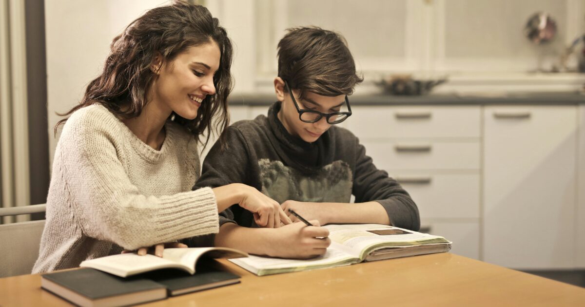 In-Blog-Thumbnails-47 A young Caucasian mom helping her son with homework at the dinner table.